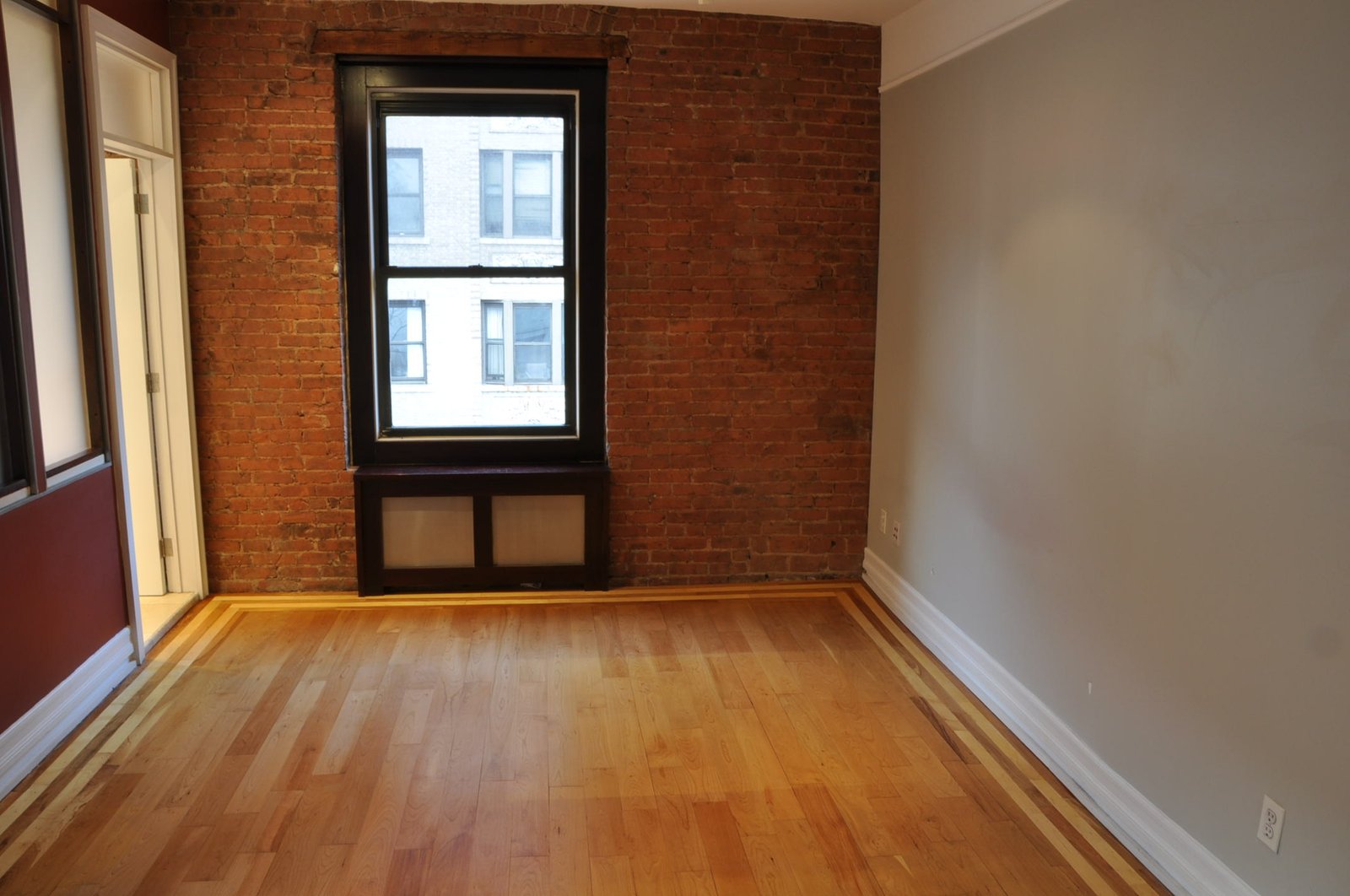 Sleeping area with full exposed brick wall and large window