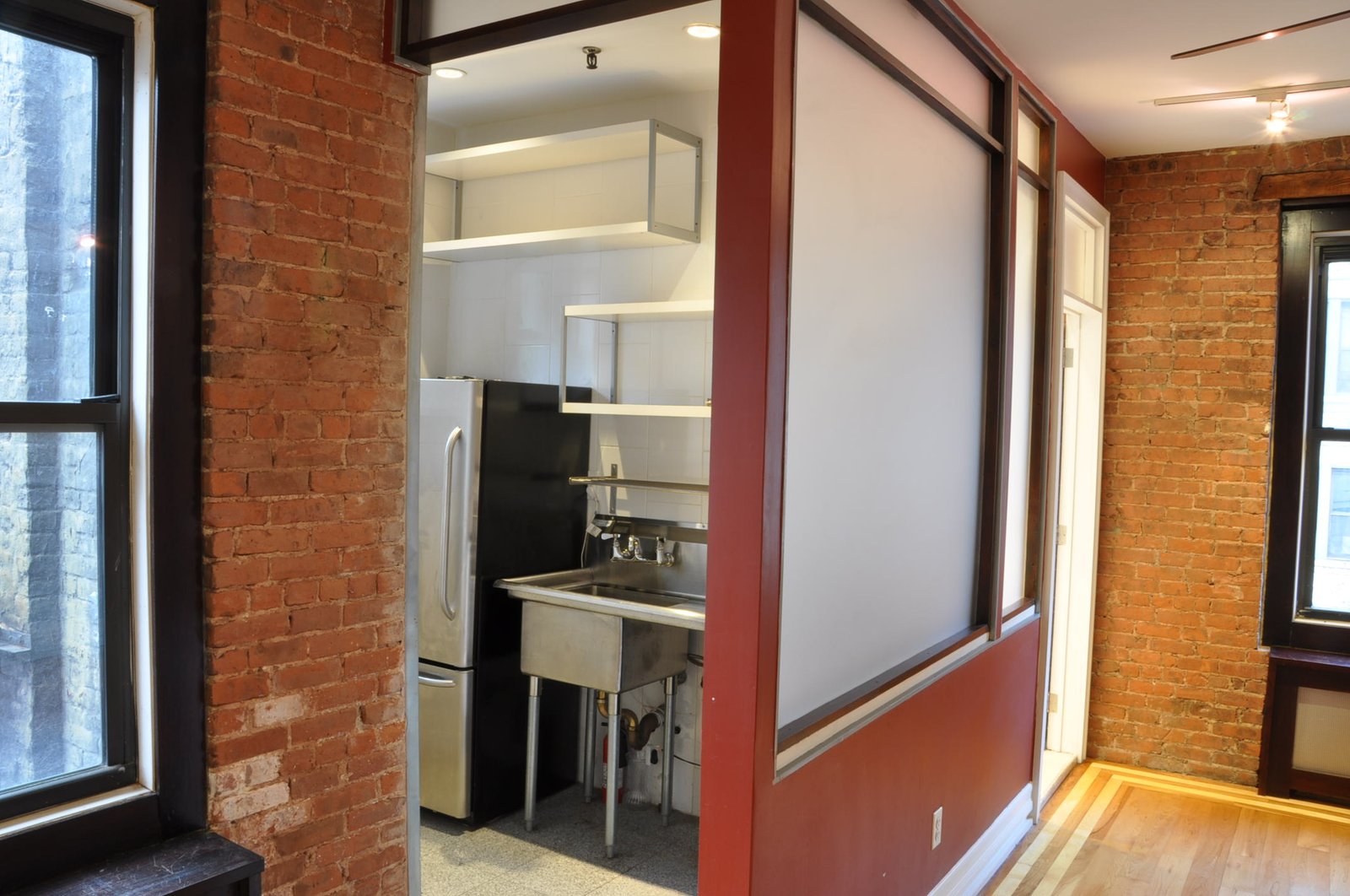 Kitchen alcove with stainless prep and exposed brick column